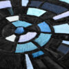 Close-up of luxury designer rug with circular mosaic in blue and black silk textures.