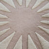 Close-up of a luxury custom designer rug in beige and cream with a sunburst pattern.
