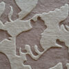 Close-up of textured, raised beige patterns on luxury handmade wool designer rug.