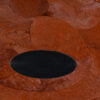 Close-up of a luxury designer rug with textured brown ovals and a black center.