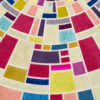 Close-up of a luxury designer rug featuring bold, colorful handmade patchwork.