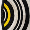 Close-up of a luxury designer rug with concentric arcs in black, white, and yellow.