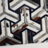 Luxury designer rug with geometric chevron pattern in black, gray, and brown hide.