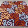 Luxury designer rug featuring bold abstract florals in blue, yellow, and orange.
