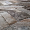 Close-up of luxury designer rug with handmade hide rectangles in brown and beige.