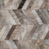 Close-up of Mr Crowley 00646 luxury designer rug with a geometric herringbone pattern in natural hide tones.