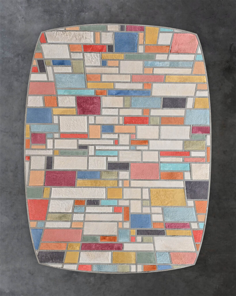 Luxury designer wool rug with geometric multicolor squares on textured gray floor.