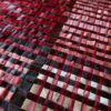 Close-up of a luxury custom designer rug in red, pink, black, and cream checkerboard.