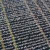 Close-up of a luxury custom designer rug with a gray, beige, and green grid pattern.