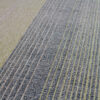 Luxury custom designer rug close-up, linear textured gray and beige high end wool bands.