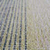 Close-up of a high end luxury custom designer rug with textured green, beige, and gray stripes.