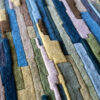 Close-up of luxury custom designer rug 02666 with geometric pattern in blue, green, yellow, and brown.