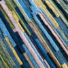 Close-up of luxury custom rug 02666’s textured surface with blue, green, yellow, and brown rectangles.