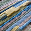Close-up of Custom 02666 luxury designer rug with textured, raised geometric patterns in blue, green, beige, and brown.