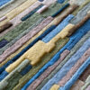 Close-up of luxury custom designer rug Custom 02666 with textured, raised multicolor patterns.