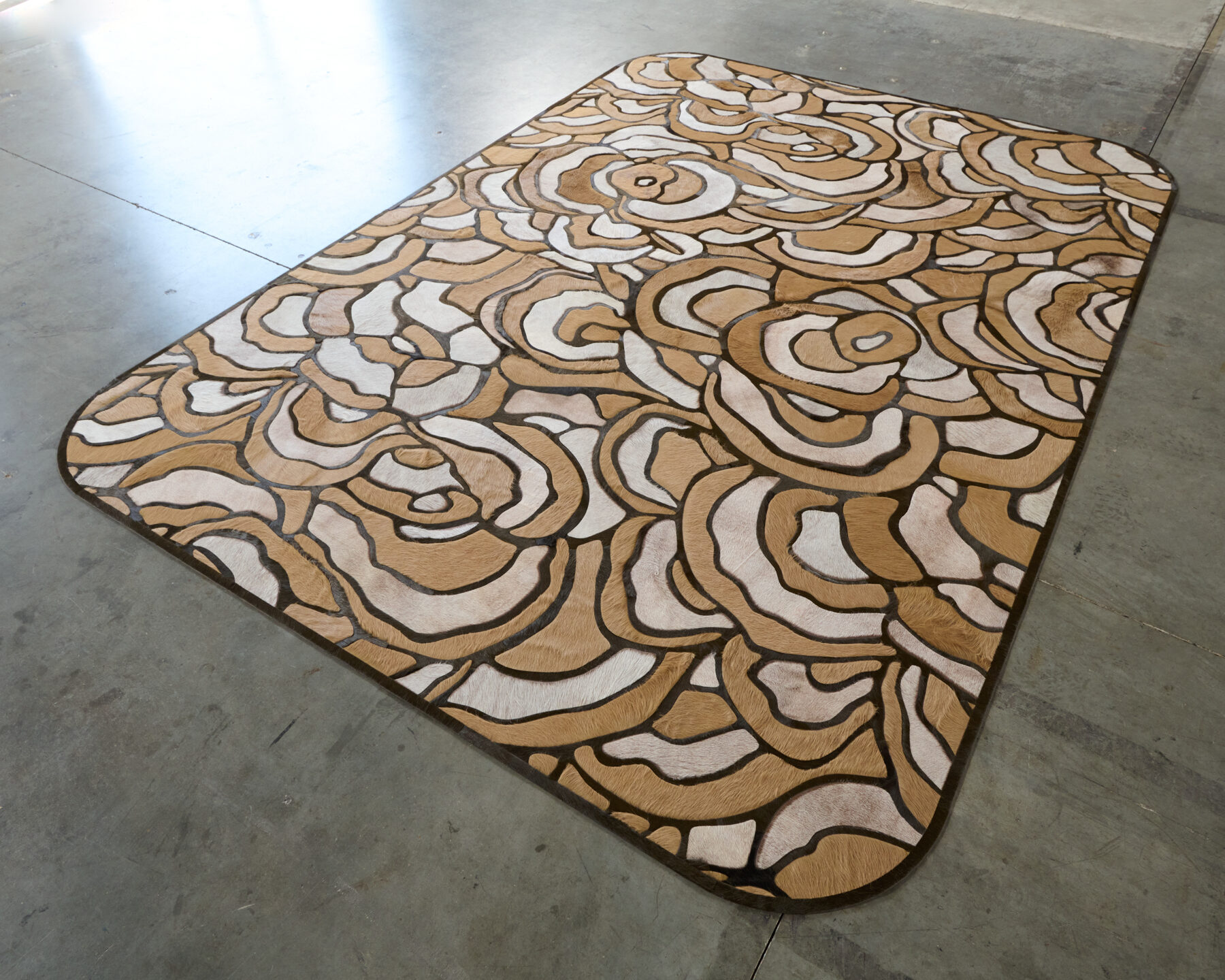 Luxury designer Bloom 21744 rug with abstract floral motif on concrete floor.
