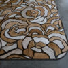 Close-up of a luxury designer rug, Bloom 21744, with abstract patterns on concrete floor.