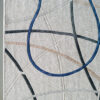 Luxury handmade wool designer rug with blue, black, and beige abstract lines on light background.