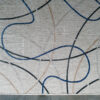 Luxury designer wool rug with light base and intersecting blue and beige lines.