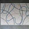 This high end designer wool rug features a light beige base and elegant curved lines in blue, black, and taupe.