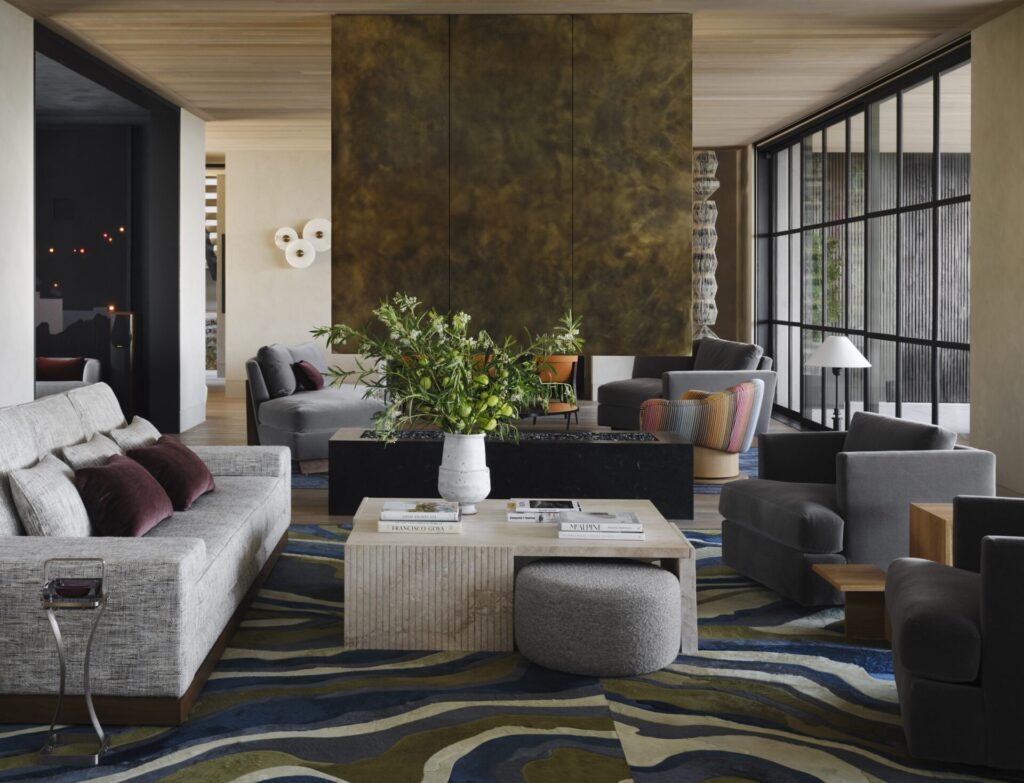 Modern living room with gray sofas and armchairs, featuring a luxury designer rug.
