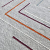 Close-up of Faceta 2321 high end designer rug with textured gray base and colorful angular lines.