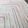The Faceta 2321 is a luxury designer rug, hand-tufted with multicolored geometric lines on a light background.