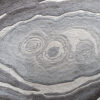 Close-up of a luxury custom rug with gray concentric wavy rings, ideal as a high end designer rug.