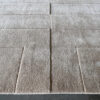 Luxury custom designer rug in beige with geometric embossed patterns, high end wool design.