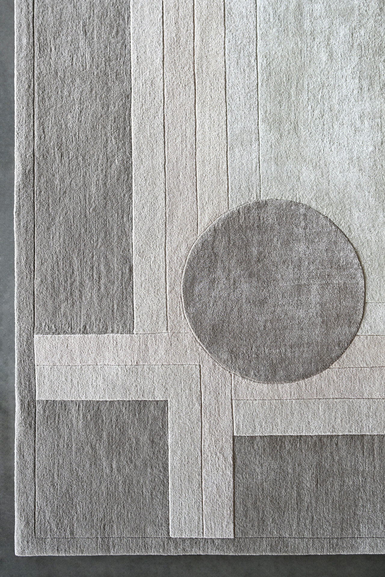Atlas 03141 luxury designer rug features geometric gray and beige patterns with intersecting lines and a bold circle accent.