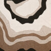 Luxury custom designer rug with abstract beige, brown, and black layered shapes reminiscent of geological patterns.