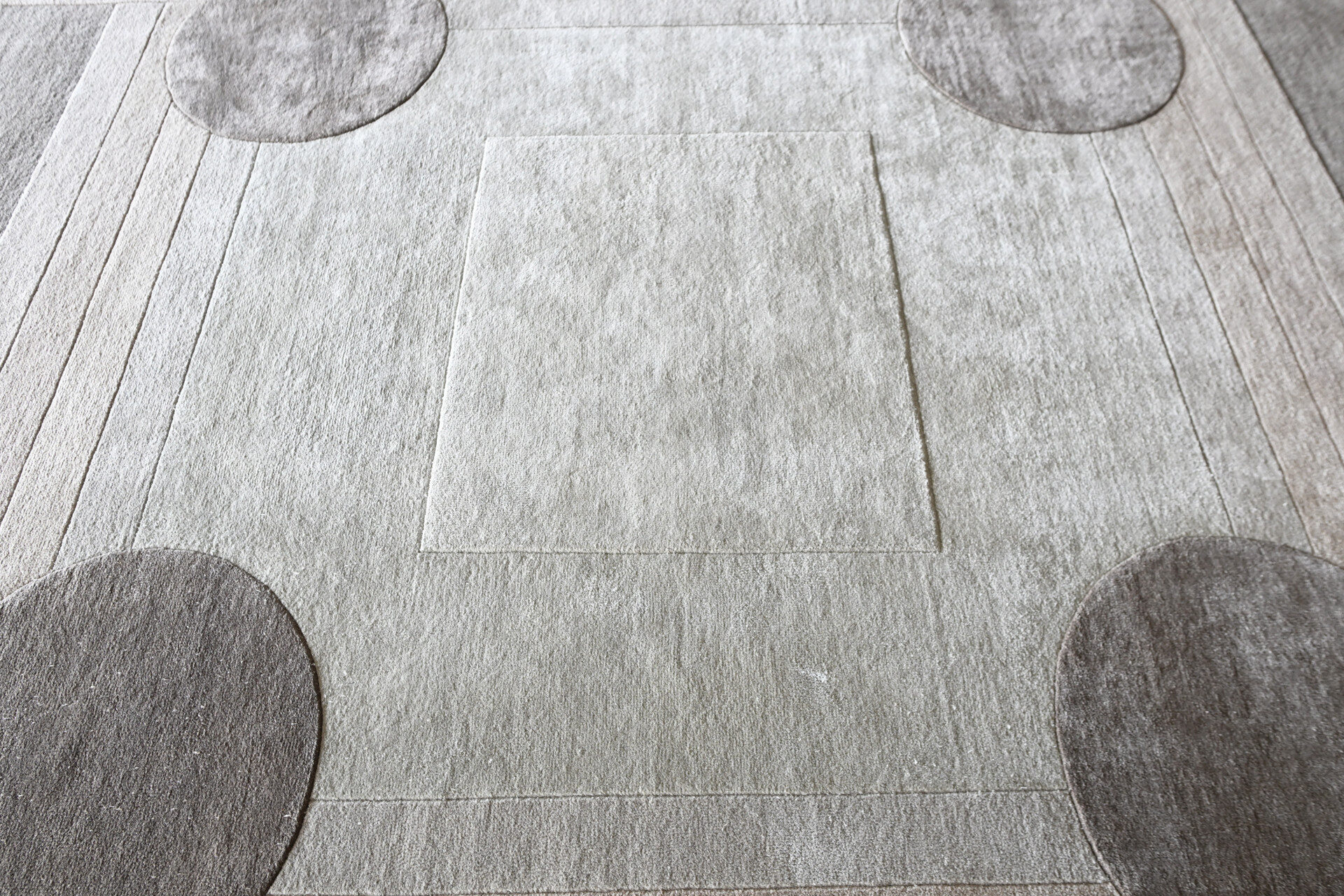 Atlas 03141 luxury designer rug in light tones, features a geometric motif and four dark accents near corners.