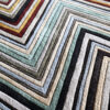Close-up of luxury designer rug Custom 03524, handmade wool with geometric multicolored concentric squares.