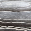 Luxury custom designer rug with gray and white concentric rings and wavy lines.