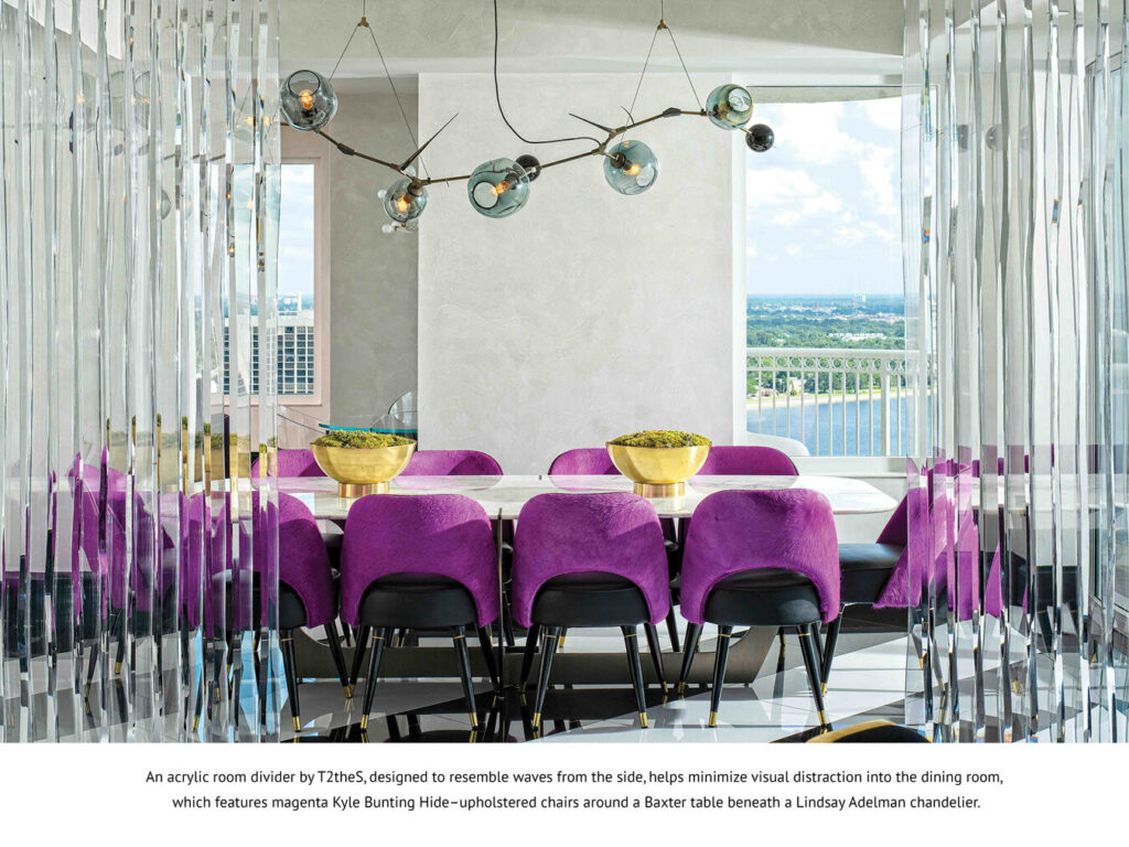 A modern dining room with magenta chairs and a gold table atop a luxury custom rug.