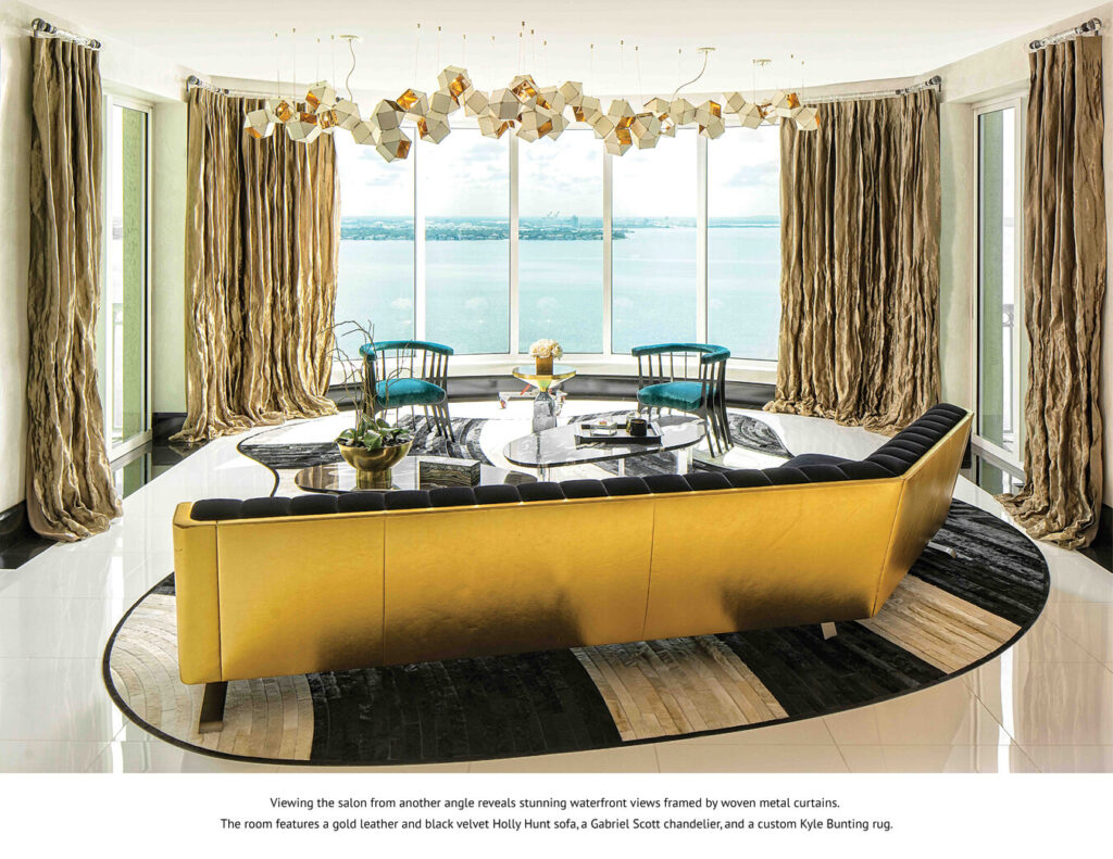 Modern living room with luxury designer rug, gold sofa, and waterfront view.