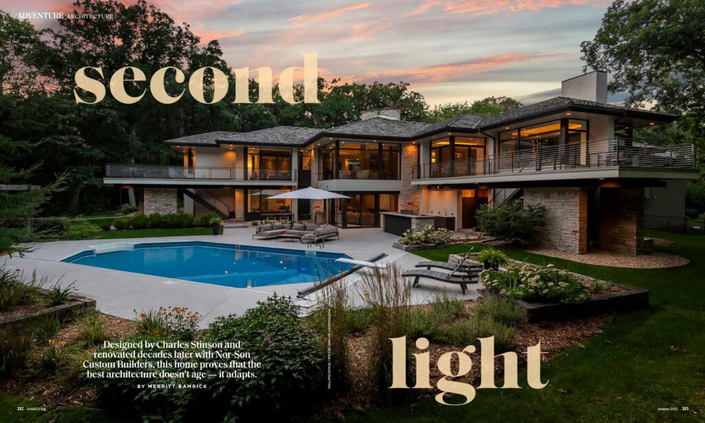 Modern two-story home with large windows and balconies, accented by luxury designer rugs visible through the glass.