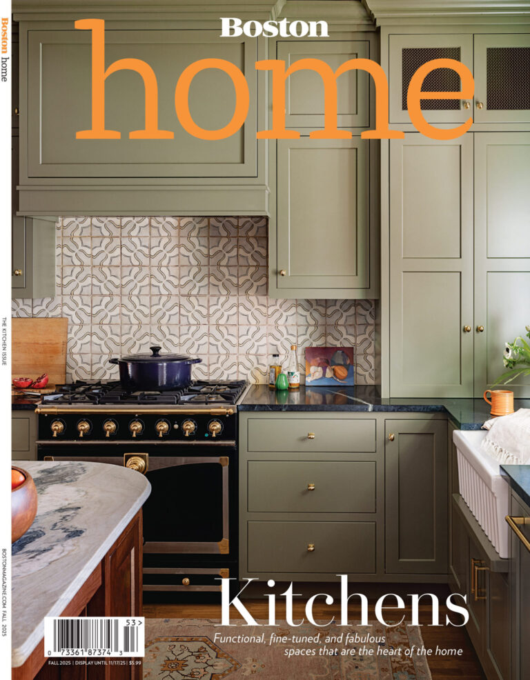 A green kitchen with marble countertops and a luxury custom designer rug by the sink.