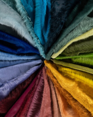 Fan-shaped luxury designer rug with hair-on-hide, blending cool to warm tones for a vibrant, high-end accent.