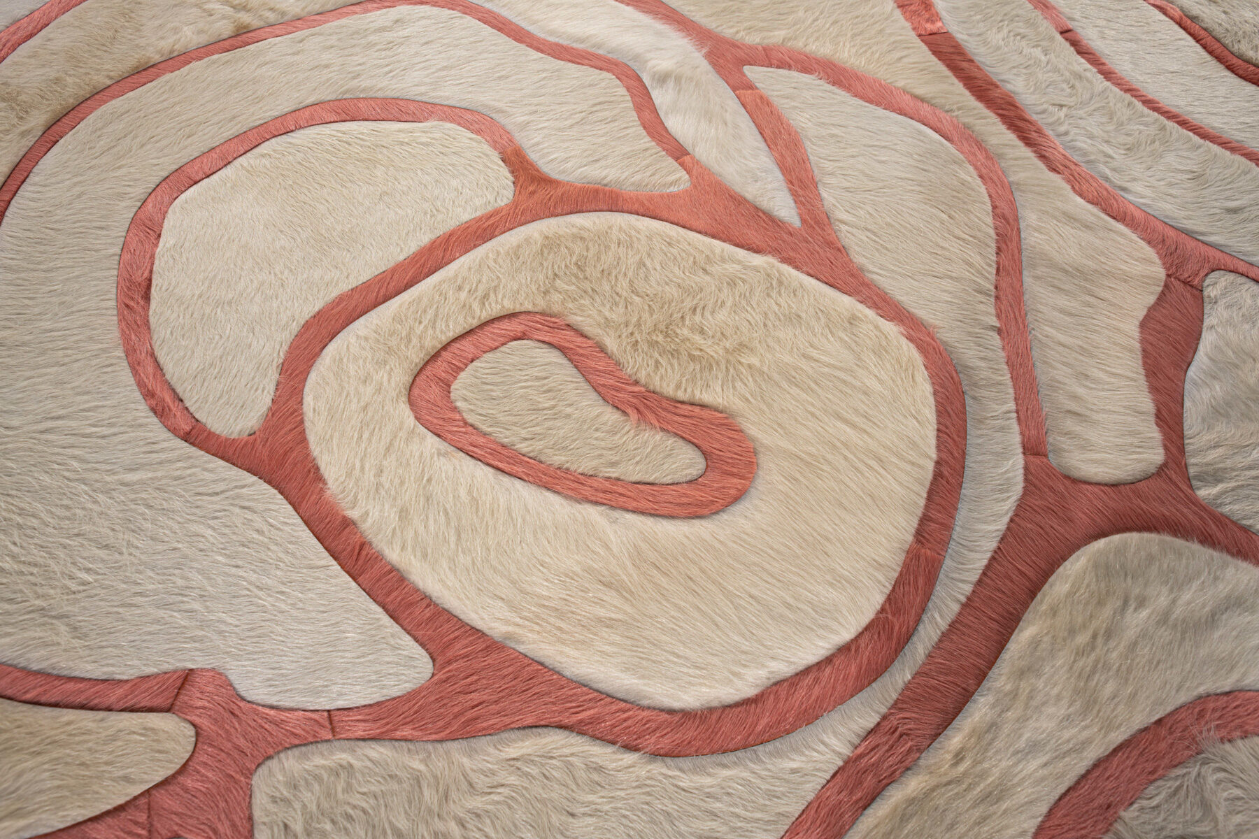 Close-up of Bloom 13575, a luxury designer rug with textured cream and pink swirls.