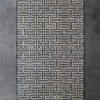 The Ripcord 10072010 high end designer rug with a black Greek key pattern on concrete.