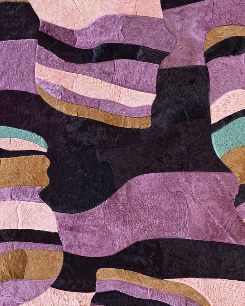 Luxury designer rug with patchwork of pink, purple, and green in a textured, high-end abstract pattern.