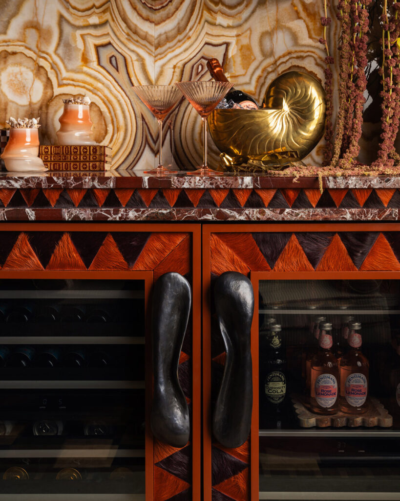 A Moniomi bar area with luxury designer rugs and a patterned stone backsplash.