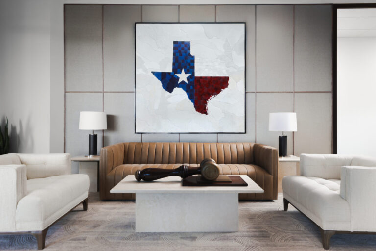 Modern office lounge with designer rug, tan sofa, and Texas artwork on the wall.