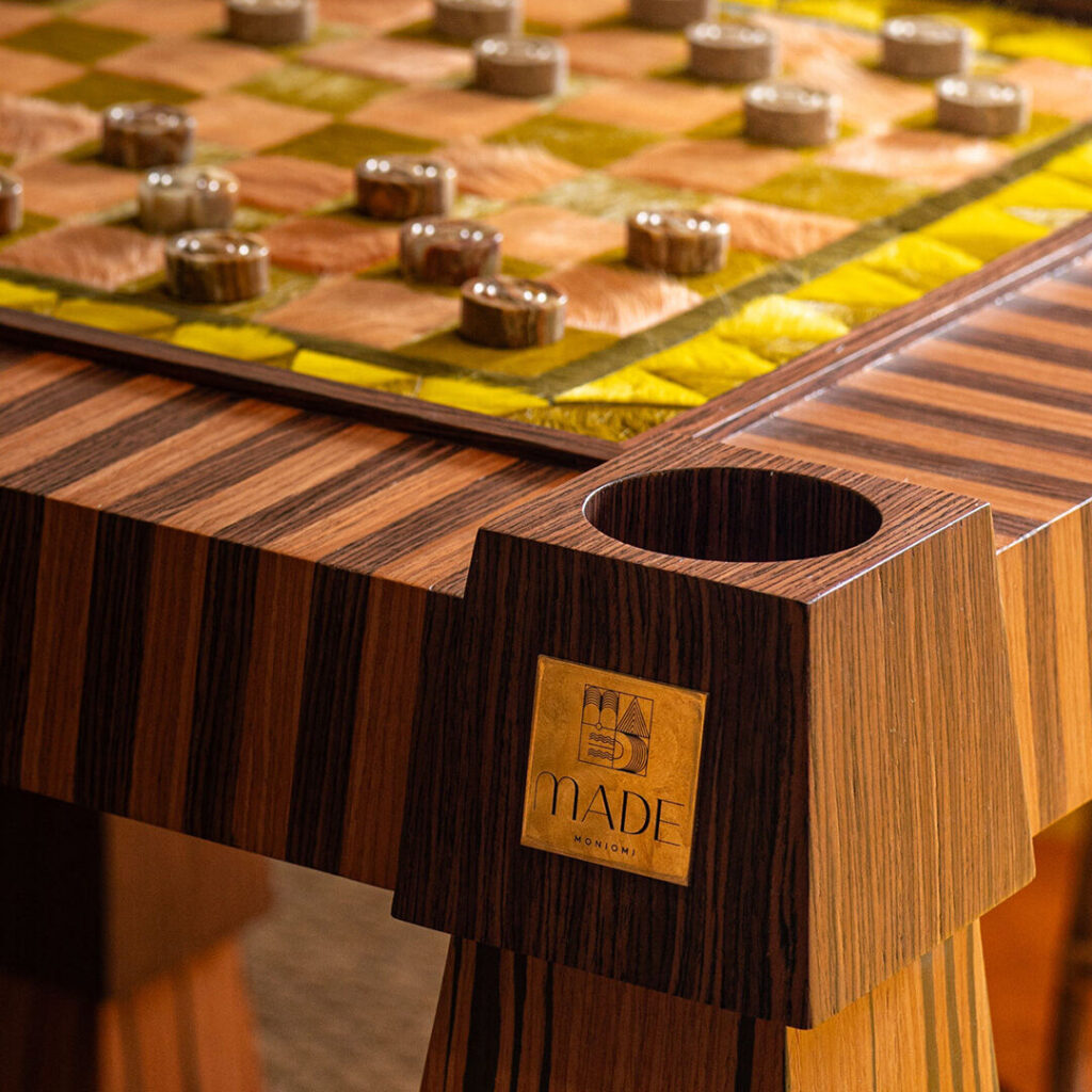 A close-up of a striped table on a luxury designer rug, with round pieces and 'MADE' engraving.