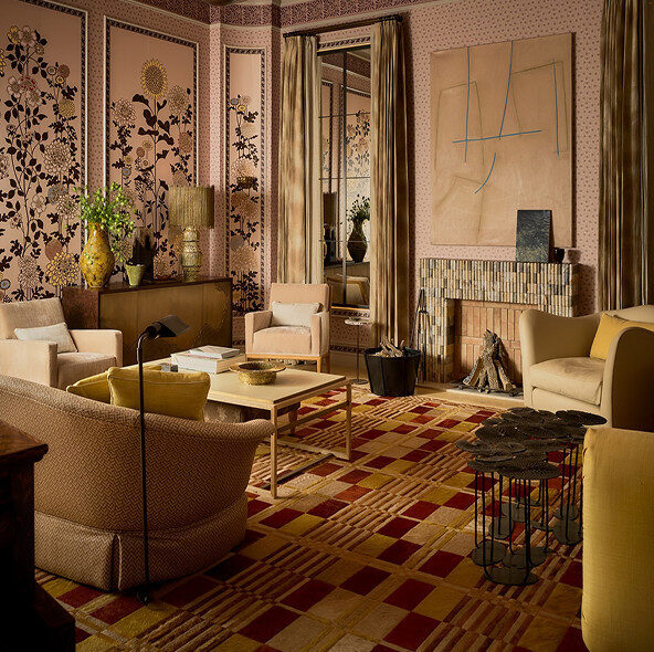 A living room with luxury designer rugs, patterned wallpaper, and modern accents.