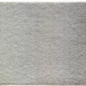 A close-up of a high-end designer rug, rectangular and light gray with a plush, textured surface.