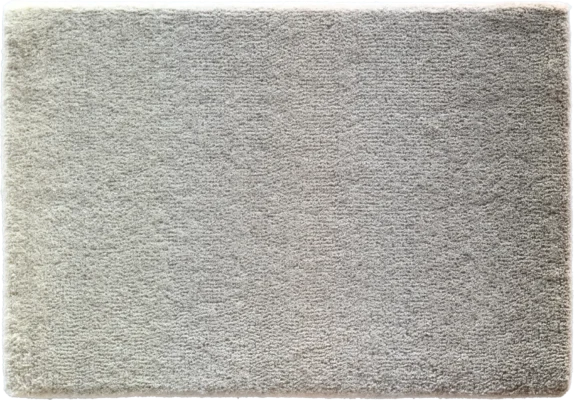 A close-up of a high-end designer rug, rectangular and light gray with a plush, textured surface.
