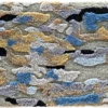 Luxury designer rug in a blue, grey, tan, and beige camouflage pattern with tufted texture.