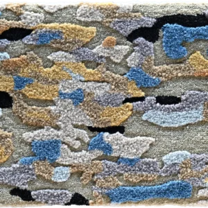Luxury designer rug in a blue, grey, tan, and beige camouflage pattern with tufted texture.